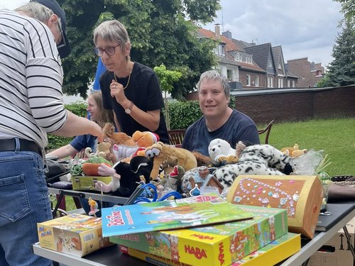 Bewohner sitzt hinter seinem Trödeltisch und verkauft