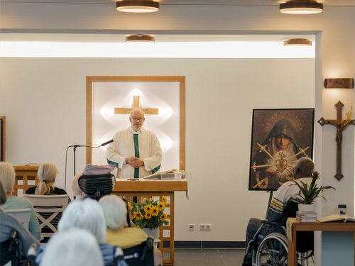 ein Pfarrer haelt eine Predigt wo die Bewohner dabei teilnehmen dürfen 