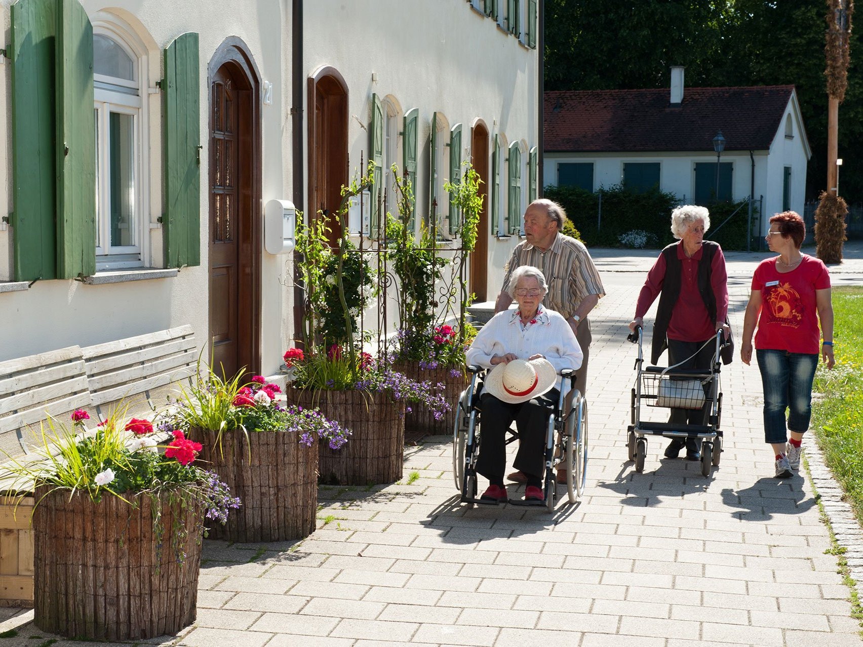 Drei Bewohner beim Spaziergang mit einer Mitarbeiterin vom Altenheim Oberdischingen