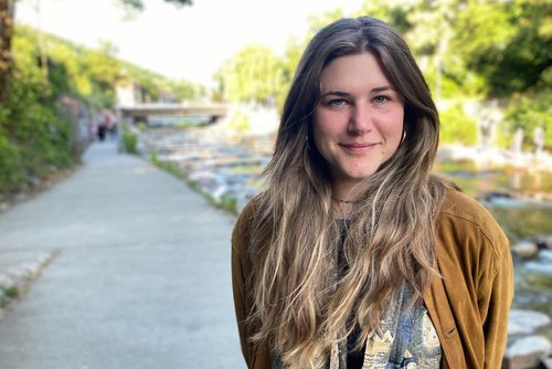 37°Leben: Cannabis - zwischen Rausch und Rettung": Nahaufnahme: Protagonistin Leah steht in einer Gartenanlage in Freiburg und schaut lächelnd in die Kamera.