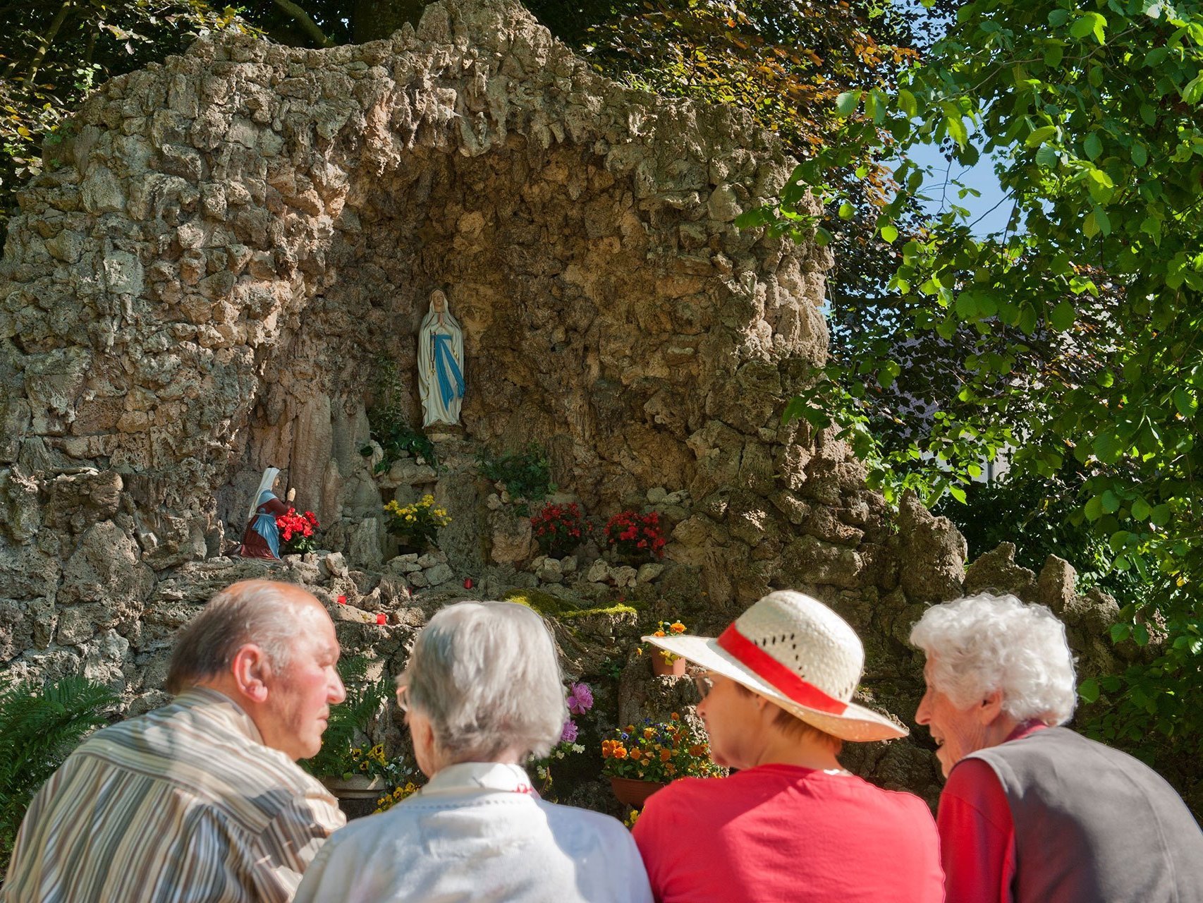 Bewohner des Altenheims Oberdischingen stehen vor einer Gedenkstätte mit Blumen und Kerzen